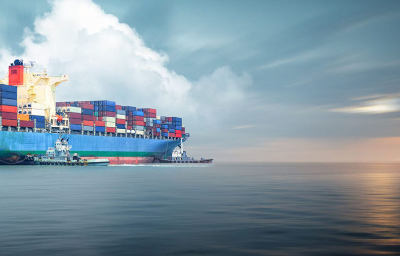 Container cargo ship in ocean at sunset