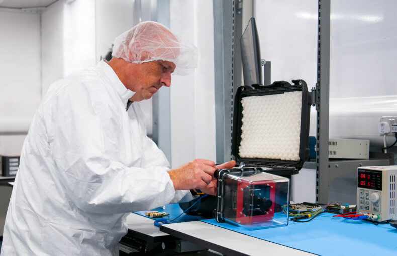 Satellite engineer working on a satellite payload